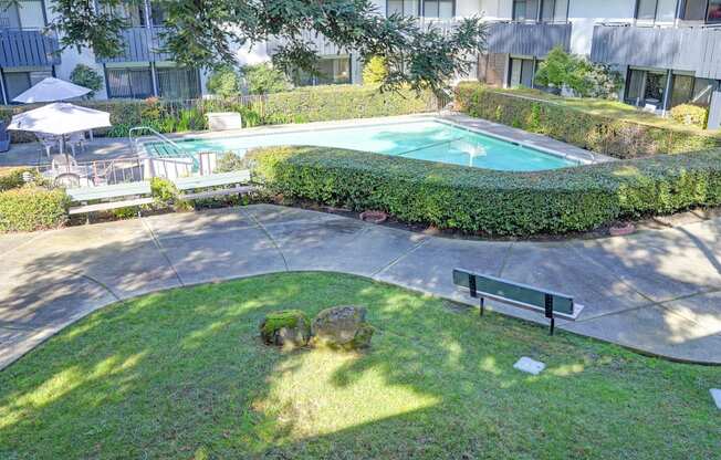 a backyard with a swimming pool and a bench