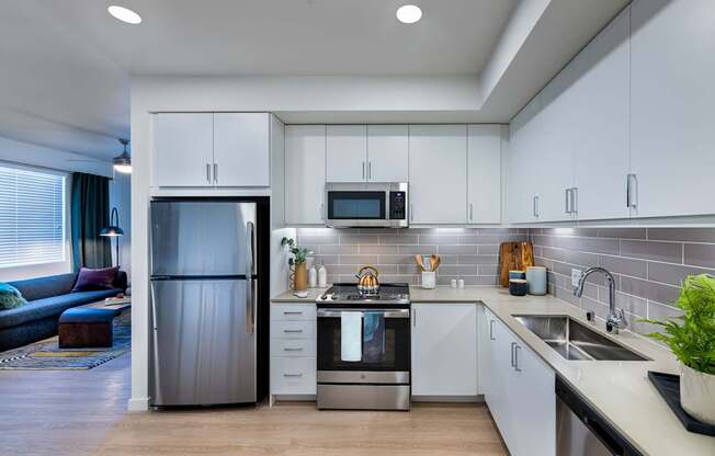 a kitchen with white cabinets and a stainless steel refrigerator