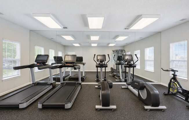 A spacious gym with treadmills, exercise bikes, and other equipment.