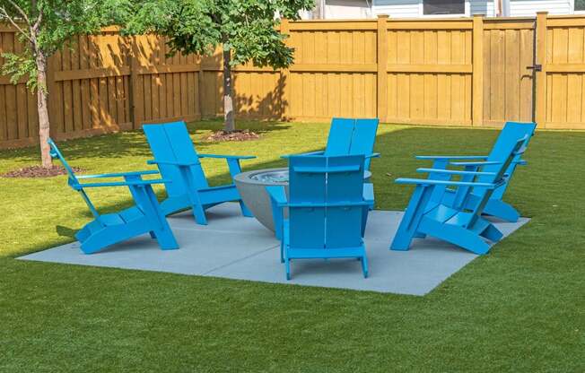 A set of blue lawn furniture is arranged on a green lawn.