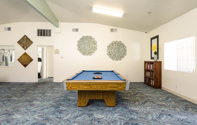 a game room with a pool table and a book shelf