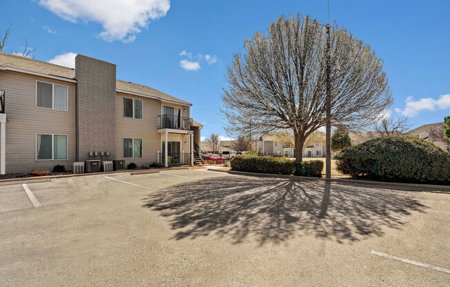 A spacious parking area at Acacia Park with convenient resident parking, mature trees for shade, nearby apartment entrances, and a calm, open layout that makes coming and going easy.