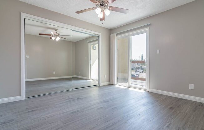 an empty room with a ceiling fan and a door