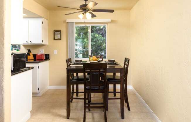 a dining room with a table and chairs and a ceiling fan