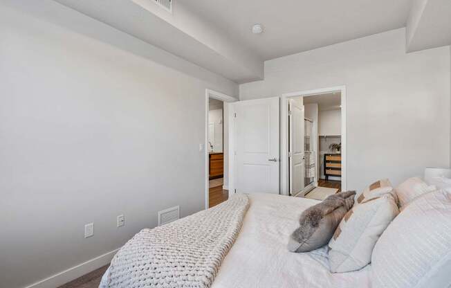 a bedroom with a large bed and a door to a bathroom