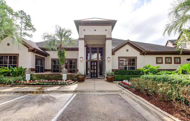 the front entrance of a house with a driveway and plants