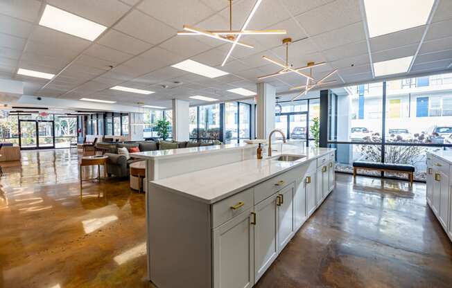 a large room with an island in the middle of a kitchen and a living room