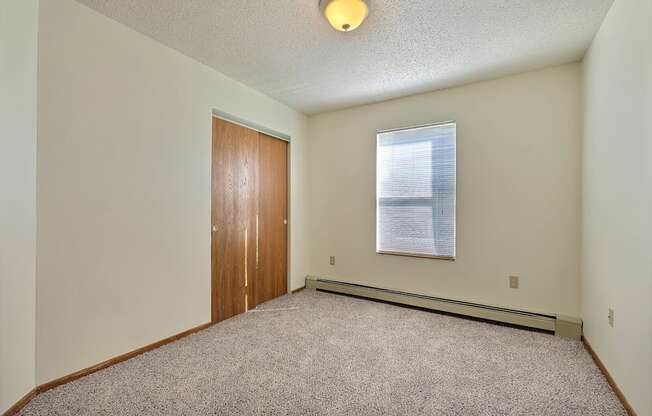 Bedroom with carpet and a door to a bedroom at Park Place Apartments in Fargo
