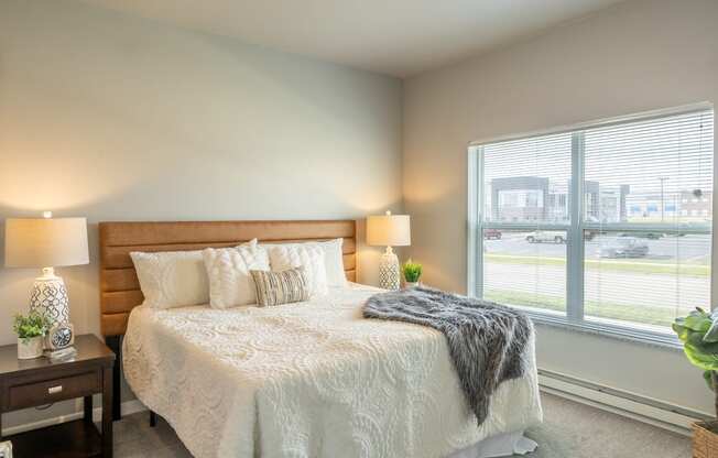 a bedroom with a bed and a large window
