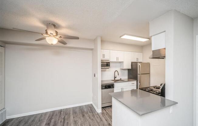 Open kitchen and living room with a ceiling fan at Avery Park in Englewood, CO