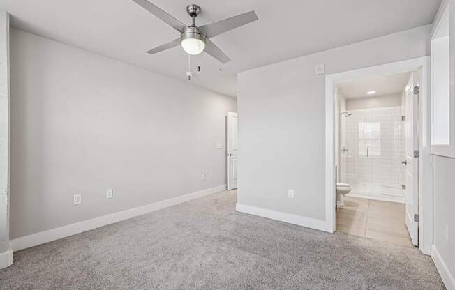 A large bedroom with a ceiling fan and a window s. a large, high ceiling, apartment that has two floors, is a modern loft, and in atlanta