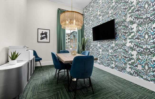 A conference room with a table, chairs, and a television mounted on the wall.