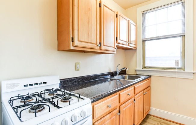 kitchen with gas range, wood cabinetry and energy efficient appliances at the foreland apartments in washinton dc