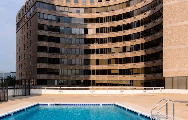 a large swimming pool in front of a large building at Hampton Plaza Apartments in Towson, MD 21286