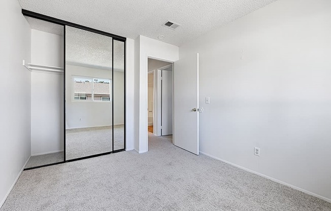 bedroom with carpet and closet with mirrored sliding doors