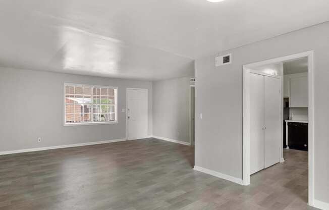 an empty living room with white walls and a window