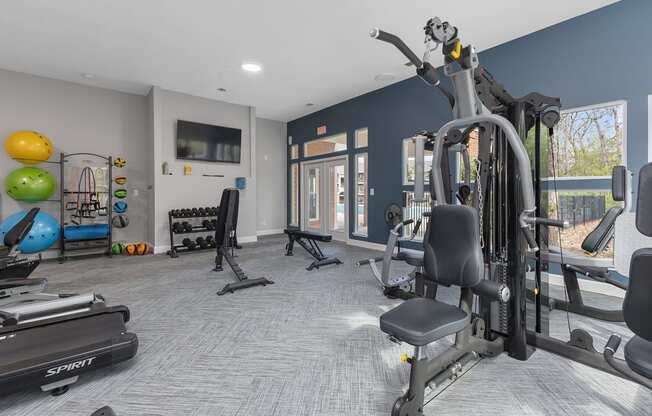 a gym with weights and cardio equipment at the enclave at woodbury apartments