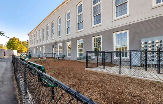 a building with a fenced in yard and a chain link fence at Highland Mill Lofts, Charlotte, NC