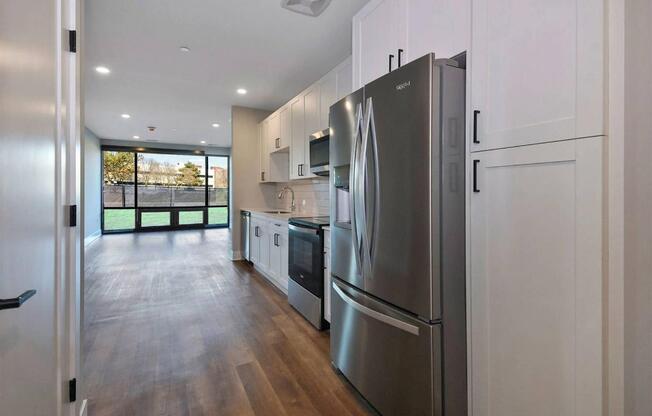A modern kitchen with a refrigerator, oven, and microwave.