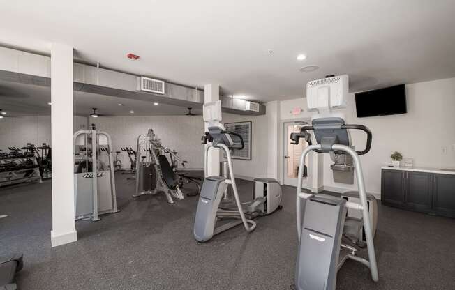 a gym with weights and cardio equipment in a building