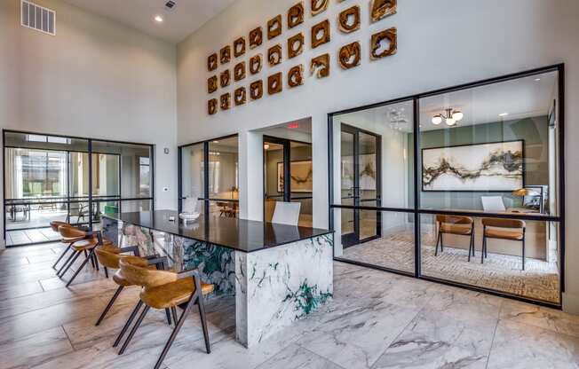 an open kitchen and dining room with a marble counter top and chairs