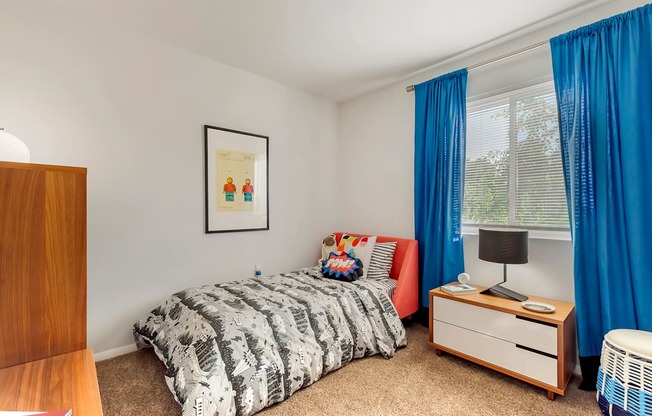 a bedroom with a bed and a dresser and a window