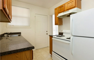 a kitchen with white appliances and wooden cabinets