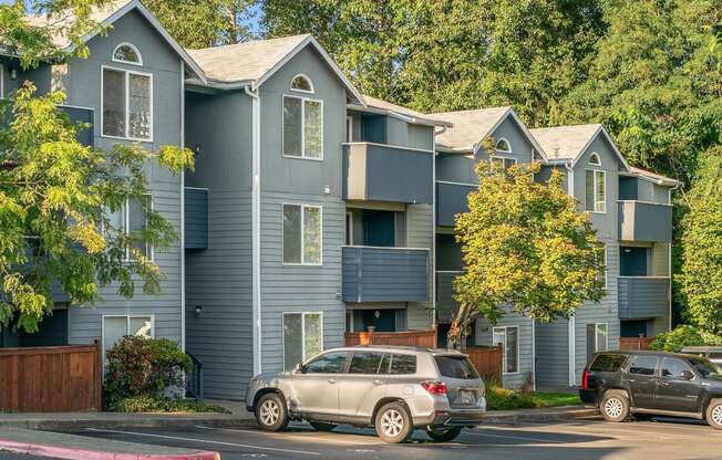 a blue apartment building with cars parked in front of it