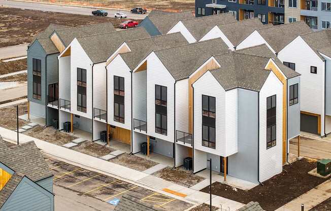 A row of houses with grey roofs and white walls.