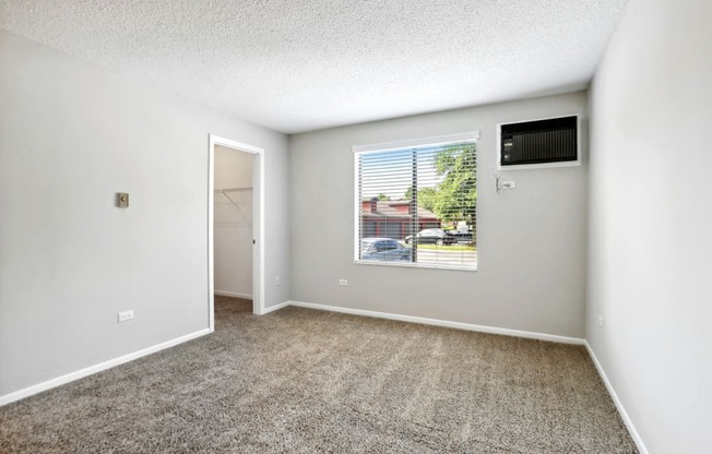 an empty room with carpet and a window