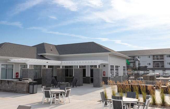 A patio area with tables and chairs in front of a building.