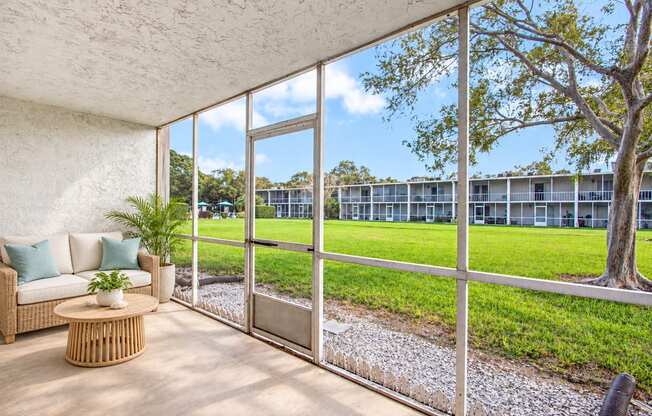 Exterior of Waterchase Apartments in Largo, FL, with trees beneath a blue sky.