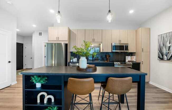 a kitchen with a blue island and three stools