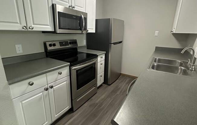 a kitchen with stainless steel appliances and white cabinets