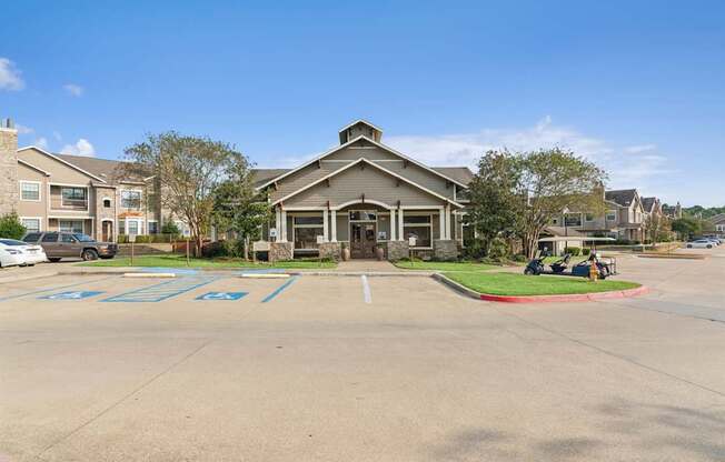 A parking lot with a building in the background and cars parked in the lot.