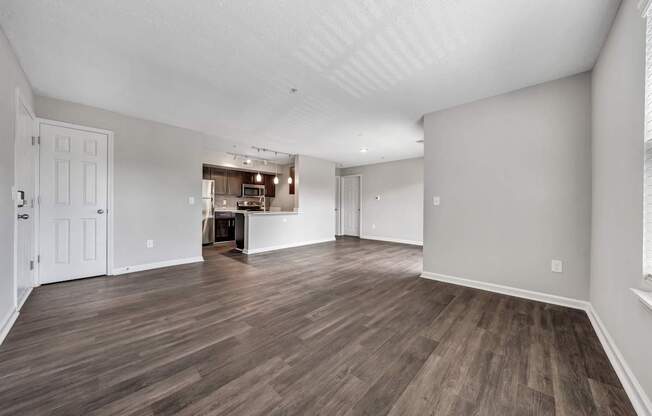 A room with wooden flooring and white walls.