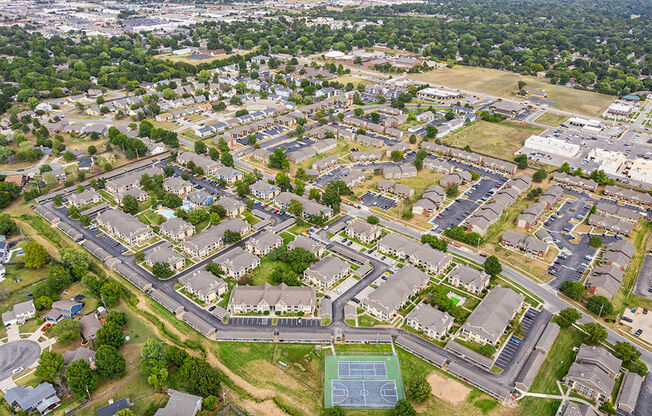 an aerial view of a city with houses and a tennis court