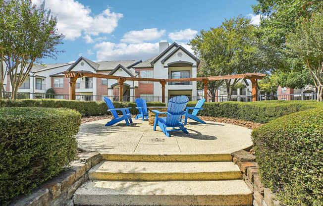 A building with a porch and blue chairs in front.