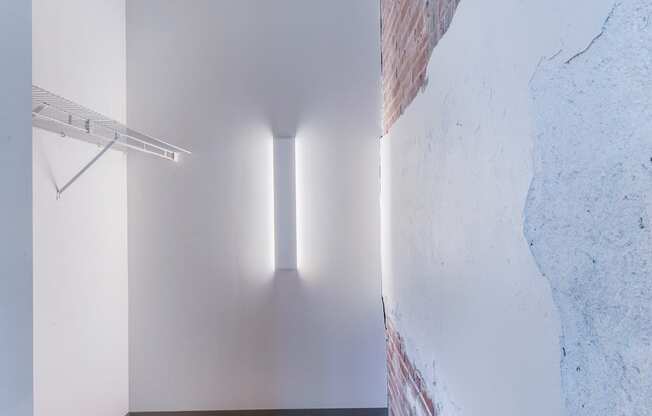 A room with a white wall and a wooden floor.