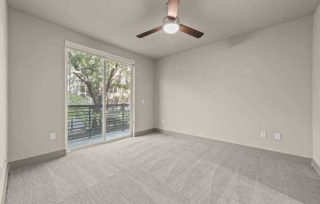 A room with a ceiling fan and carpeted floor.