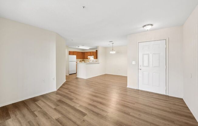 an empty living room and kitchen with a white door