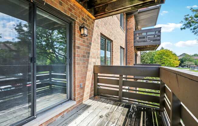 the front porch of a brick house with a wooden bench