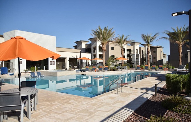 A pool area with a table and chairs and umbrellas.