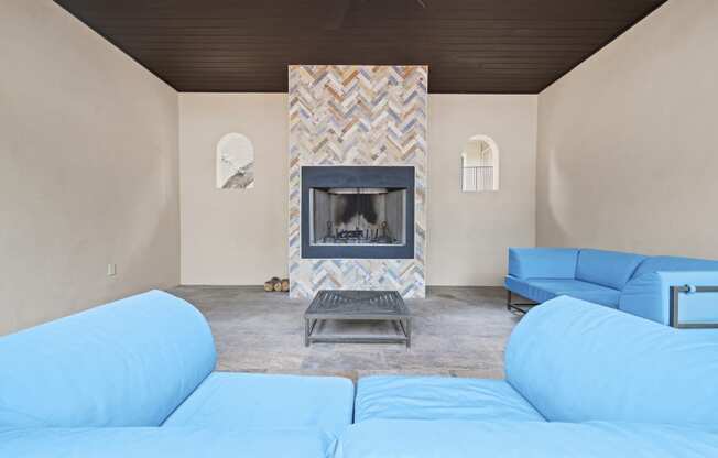 a living room with a fireplace and blue couches