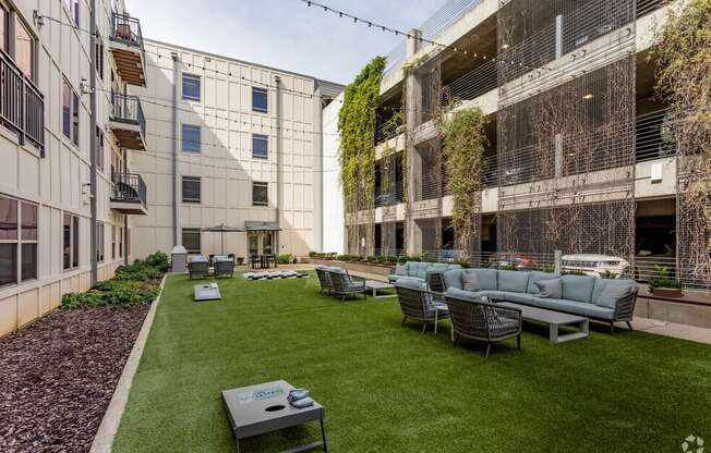 a courtyard with a couch and chairs in front of some buildings