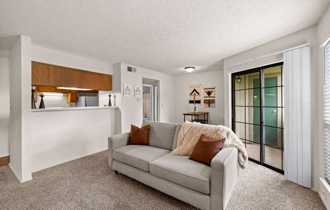 A living room with a grey couch and a wooden cabinet.