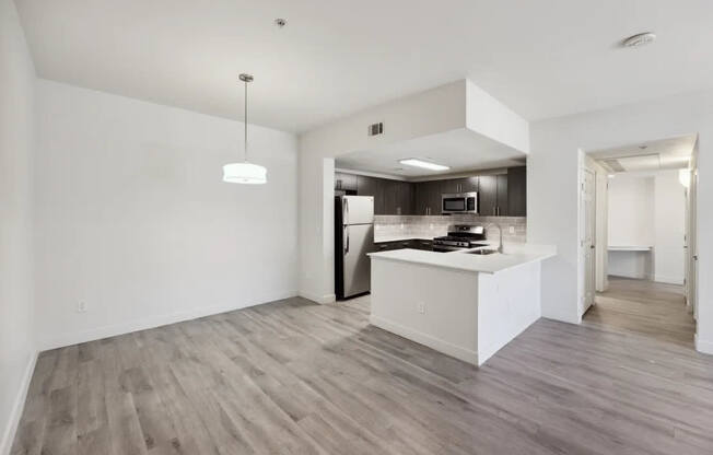A modern kitchen with a white island and wooden floors.
