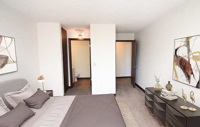 a bedroom with a large bed and a bathroom in the background