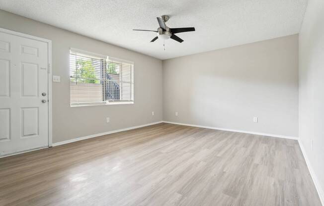 A room with a ceiling fan and a door.