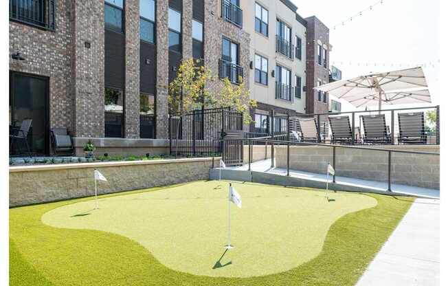 A miniature golf course is located on a patio outside of a building.